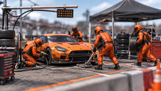 Photo-real 1:64 scale pit lane diorama with a diecast race car and miniature pit crew working during a tire change
