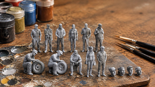Unpainted 1:64 resin figures and miniature heads arranged on a hobby workbench